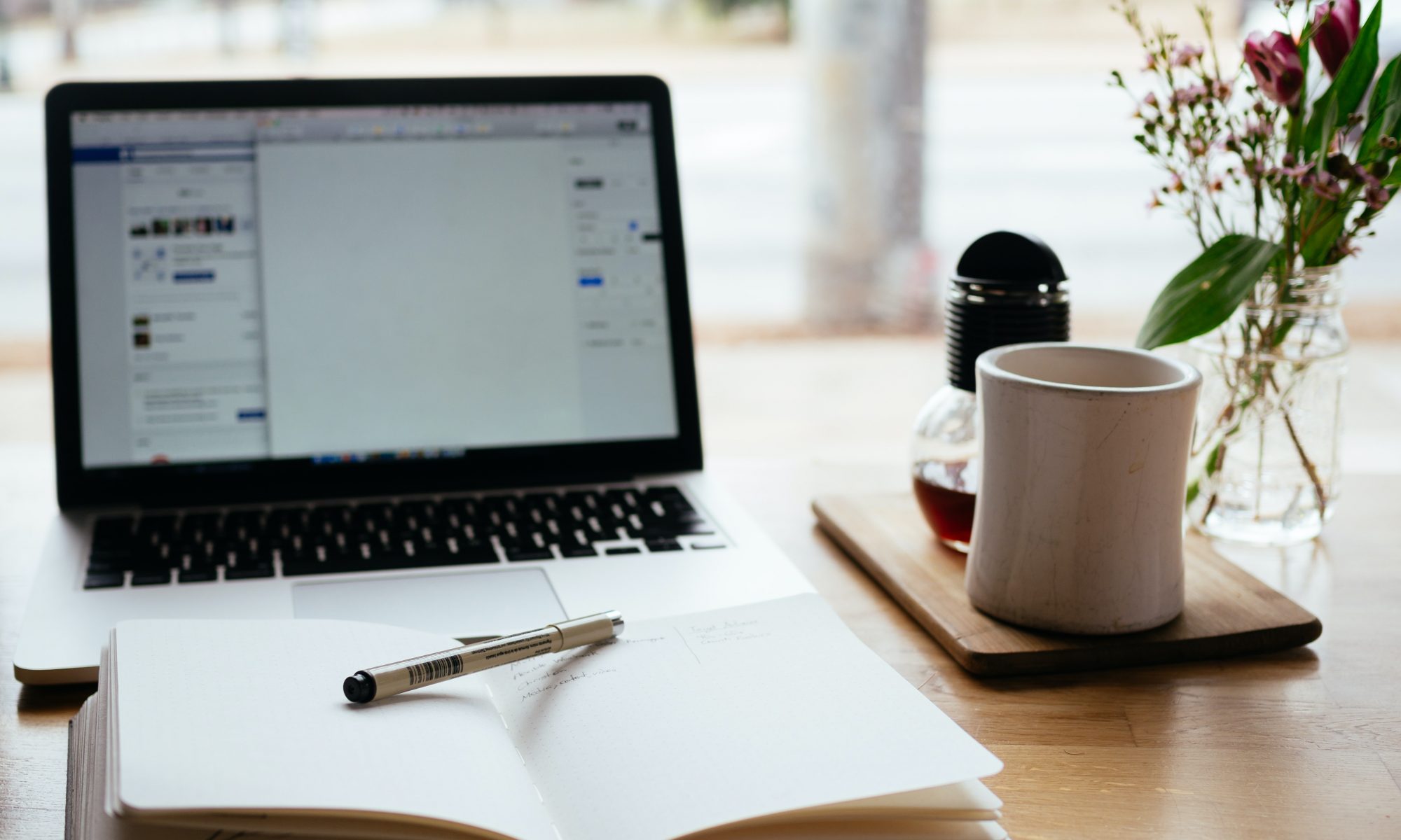 Laptop with notepad and coffee mug